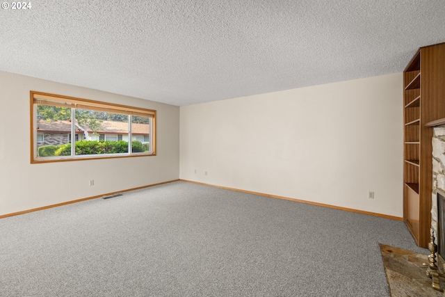 carpeted empty room featuring a textured ceiling