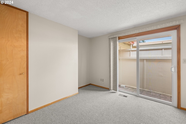 unfurnished bedroom with a textured ceiling, carpet, and a closet