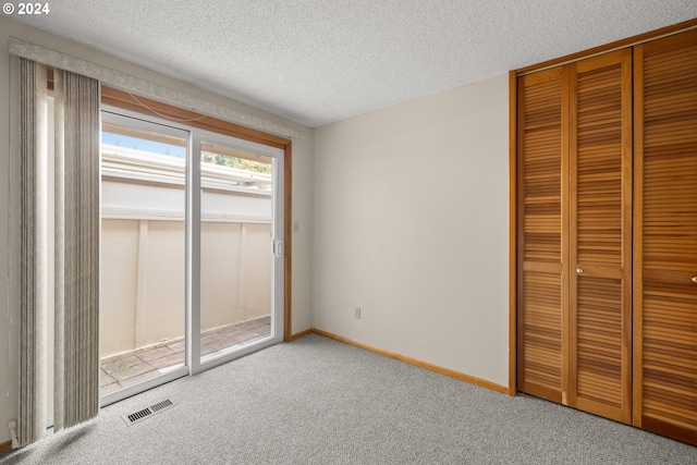 unfurnished bedroom featuring a textured ceiling and carpet floors