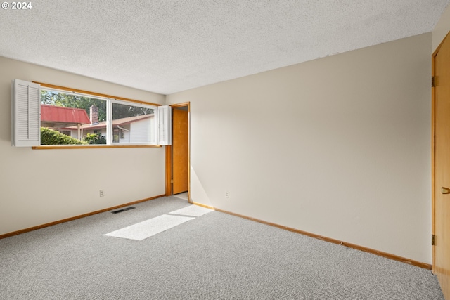 carpeted spare room with a textured ceiling