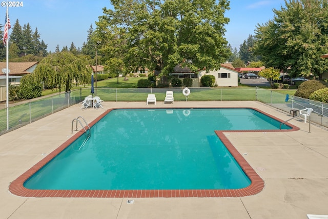 view of swimming pool featuring a yard and a patio