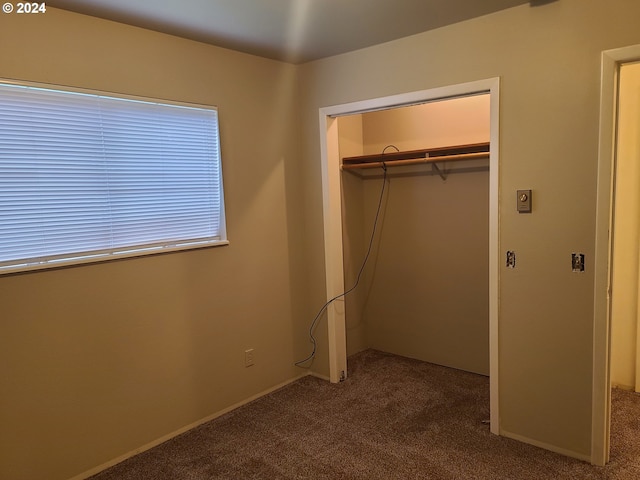 unfurnished bedroom with carpet flooring and a closet