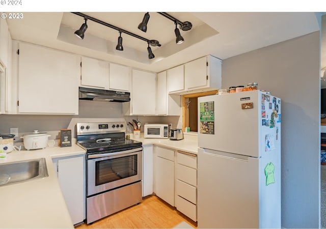 kitchen with white cabinets, white appliances, sink, and light hardwood / wood-style flooring