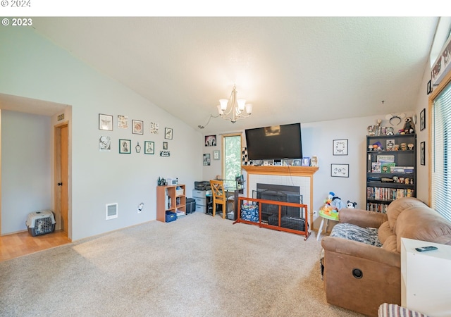 living room featuring a fireplace, carpet, lofted ceiling, and an inviting chandelier