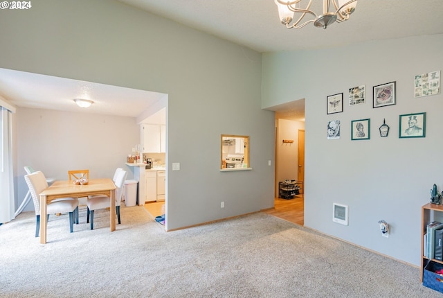 carpeted dining room with a chandelier and lofted ceiling