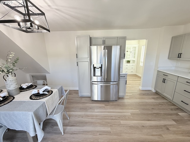 kitchen with light wood-style flooring, gray cabinets, and stainless steel refrigerator with ice dispenser