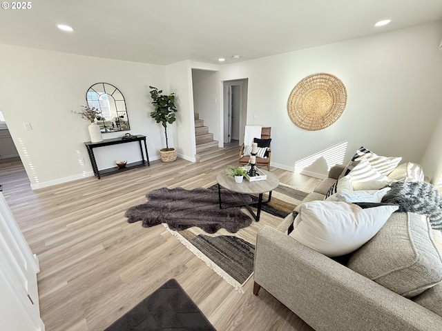 living area featuring recessed lighting, light wood-style flooring, and stairs