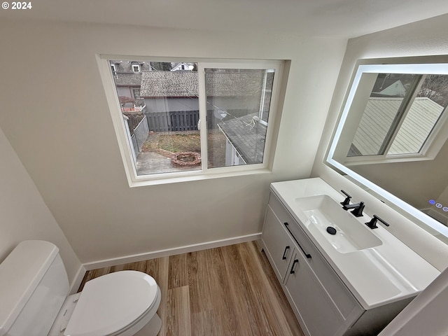 bathroom featuring vanity, wood finished floors, toilet, and baseboards