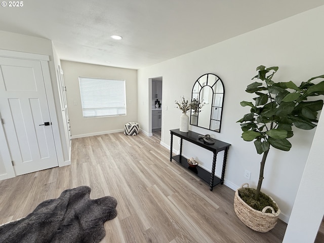 hallway with baseboards and light wood-style floors