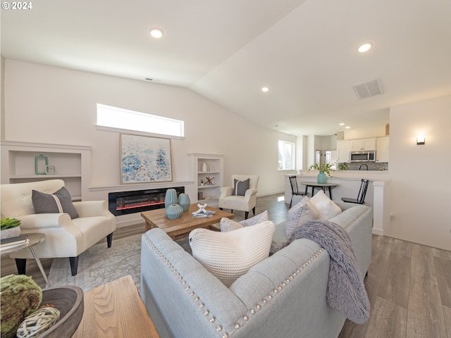 living room featuring vaulted ceiling and light hardwood / wood-style flooring