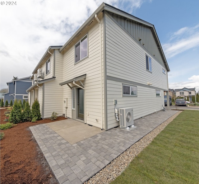 rear view of property featuring a patio, a yard, and ac unit