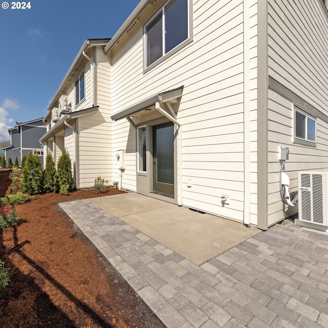 rear view of property featuring central AC and a patio area