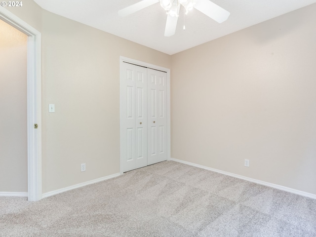 unfurnished bedroom with light carpet, ceiling fan, and a closet