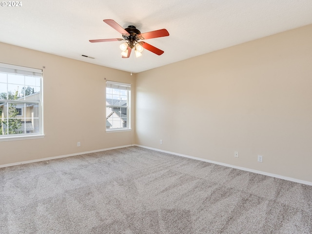 carpeted spare room with ceiling fan and a healthy amount of sunlight