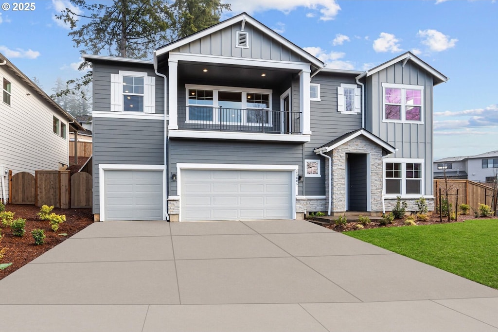 craftsman-style home featuring a balcony, a garage, and a front lawn