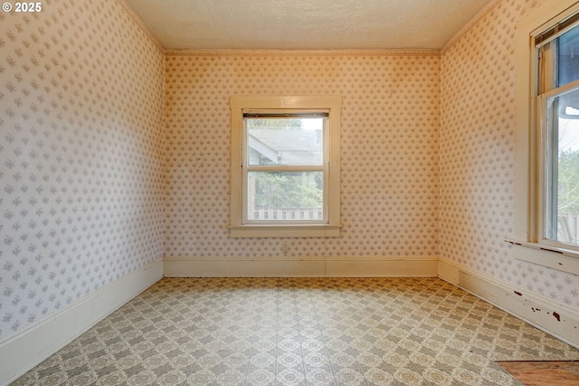 empty room with a textured ceiling and ornamental molding