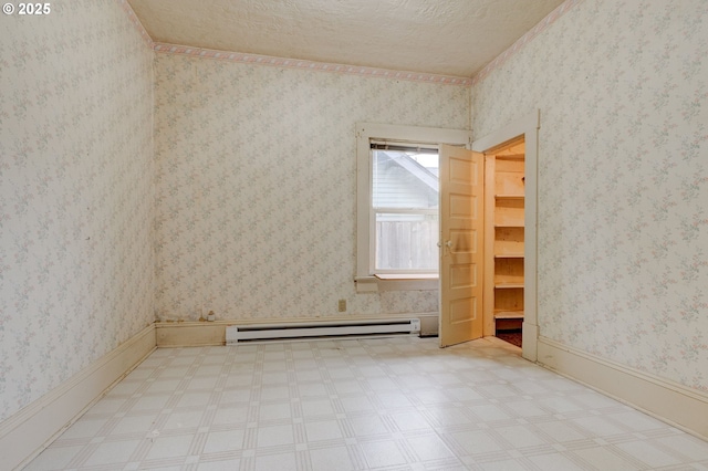 spare room featuring a textured ceiling and a baseboard radiator