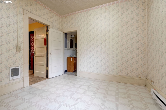 empty room with a baseboard radiator and a textured ceiling