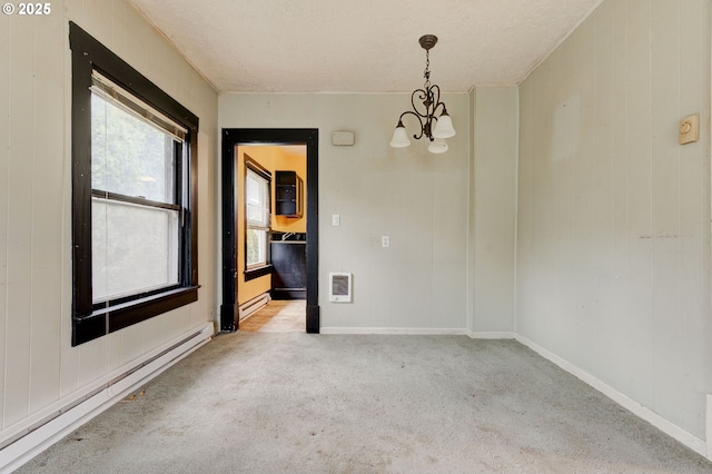 empty room featuring a textured ceiling, baseboard heating, light colored carpet, and an inviting chandelier