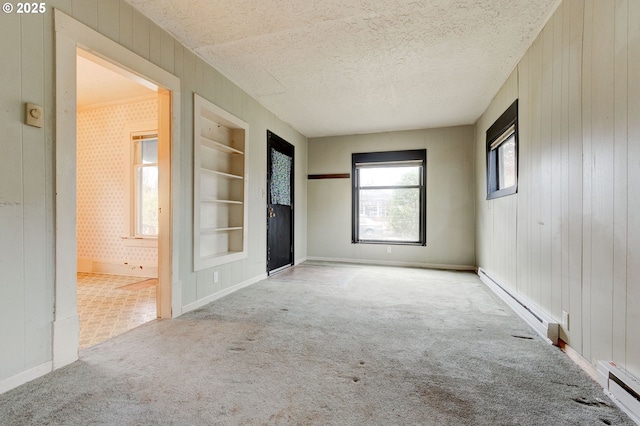 interior space with a baseboard heating unit, ensuite bathroom, light carpet, and wooden walls