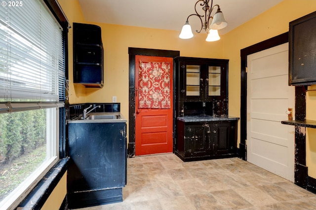 kitchen featuring sink, plenty of natural light, hanging light fixtures, and a notable chandelier