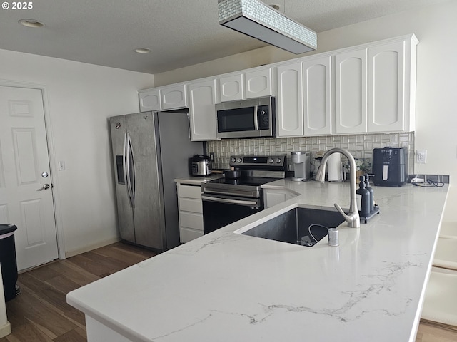 4024 NE 166th Ave, Vancouver, WA 98682 - kitchen featuring appliances with stainless steel finishes, white cabinets, decorative backsplash, wood finished floors, and light stone countertops