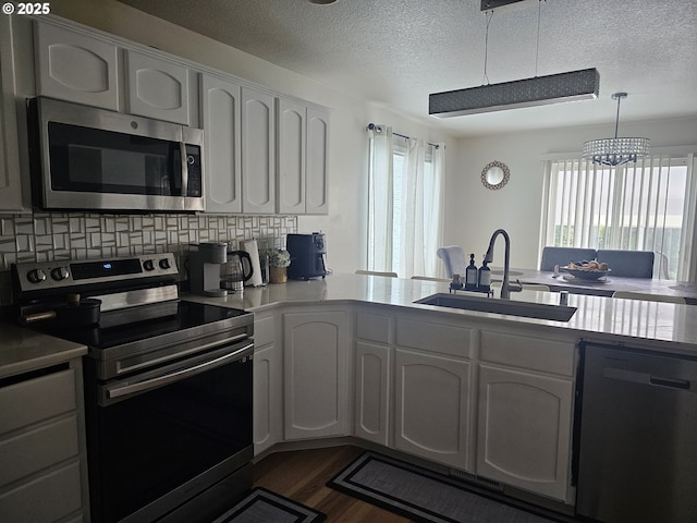 4024 NE 166th Ave, Vancouver, WA 98682 - kitchen with appliances with stainless steel finishes, a textured ceiling, white cabinetry, dark wood-style floors, and tasteful backsplash