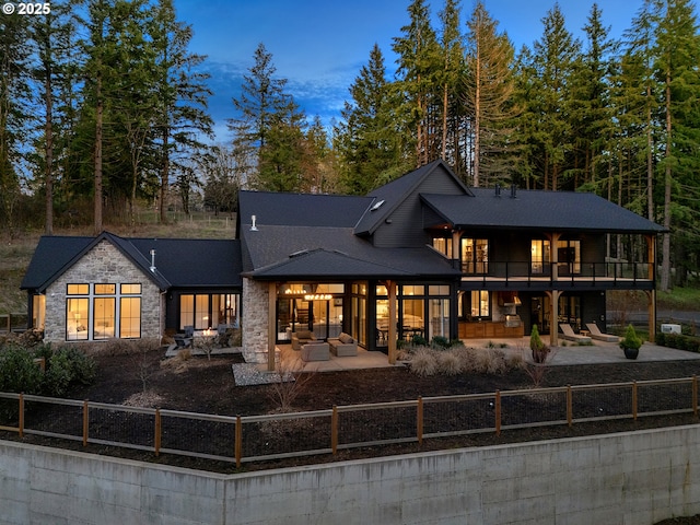 back house at dusk featuring a patio area