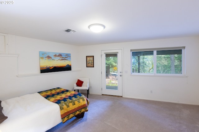 carpeted bedroom featuring access to exterior, visible vents, and baseboards