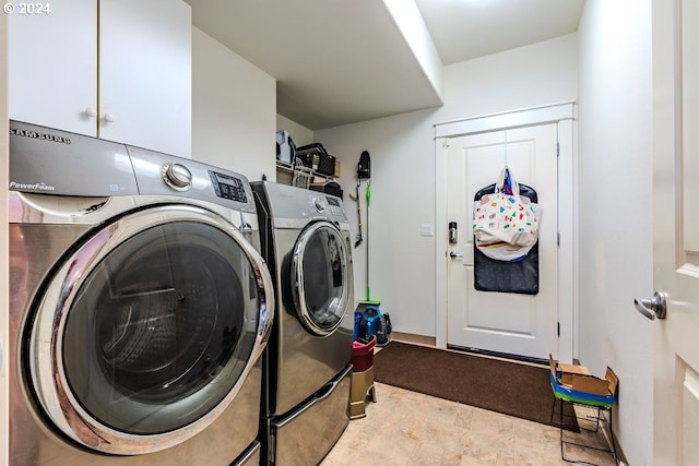 washroom with washing machine and clothes dryer and cabinets