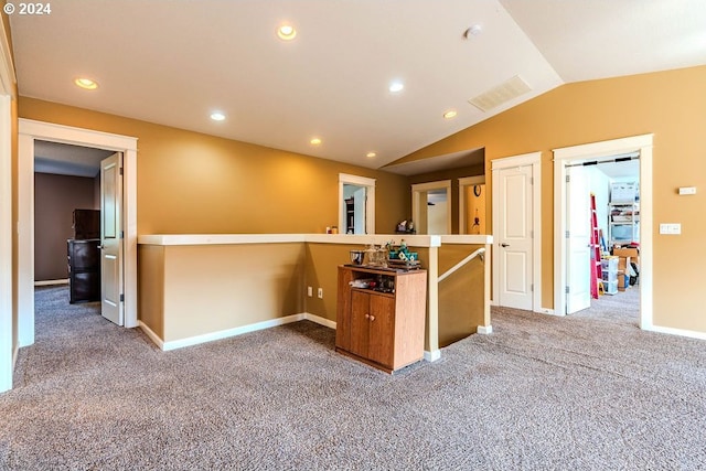 interior space with lofted ceiling, kitchen peninsula, and carpet