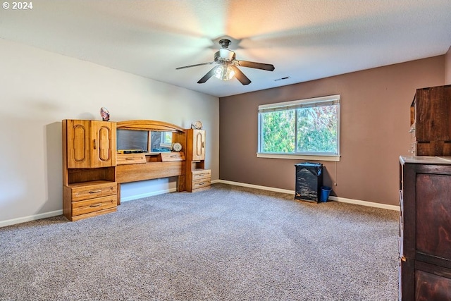 carpeted bedroom with ceiling fan and a textured ceiling