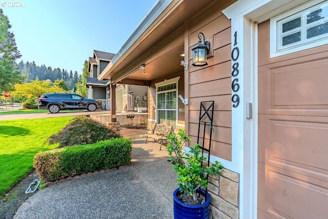 entrance to property featuring a yard and covered porch