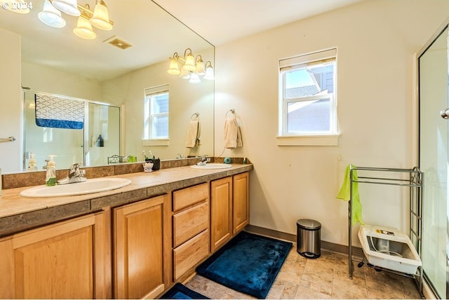 bathroom with vanity, a chandelier, and a shower with shower door