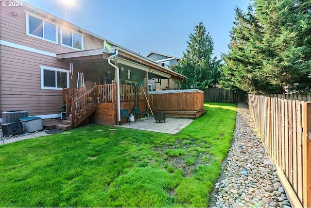 view of yard with central AC and a patio