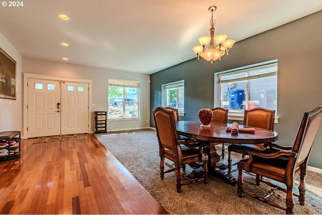 dining space featuring hardwood / wood-style floors and an inviting chandelier