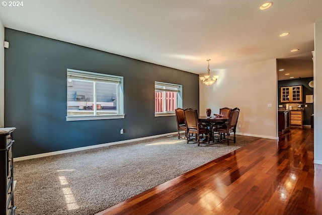 dining area featuring dark hardwood / wood-style floors and an inviting chandelier