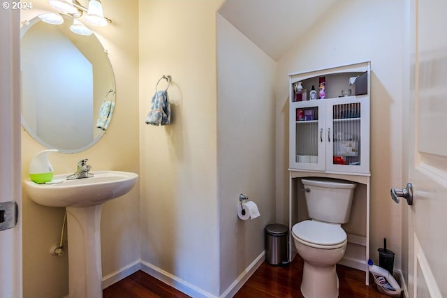 bathroom with lofted ceiling, toilet, and wood-type flooring