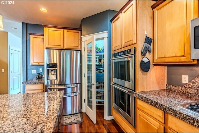 kitchen with appliances with stainless steel finishes and dark hardwood / wood-style flooring