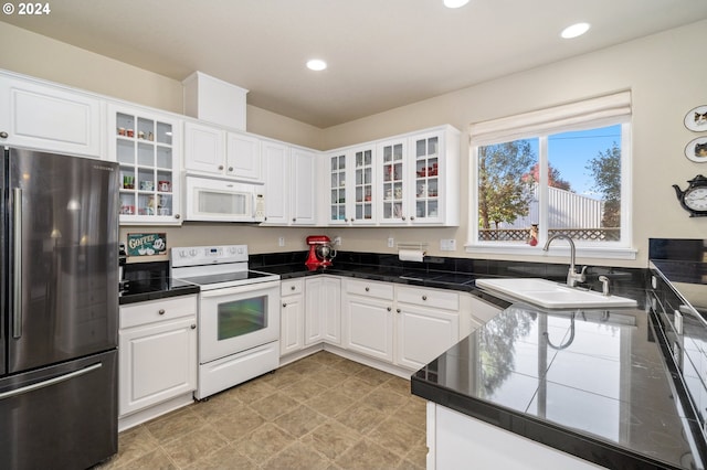 kitchen with white cabinetry, sink, and white appliances