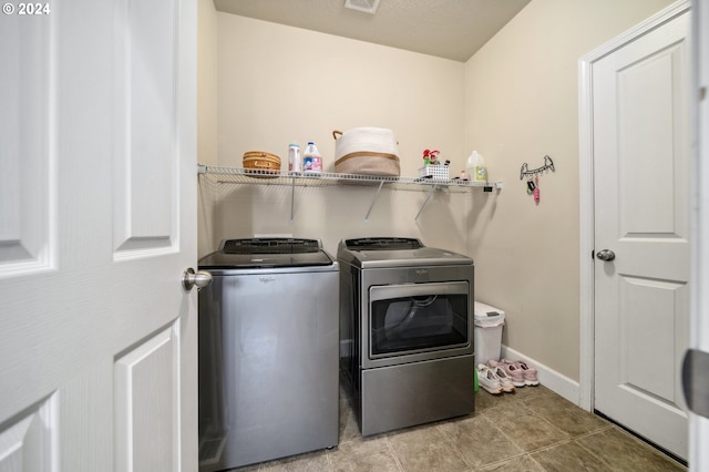 washroom with independent washer and dryer and light tile patterned flooring