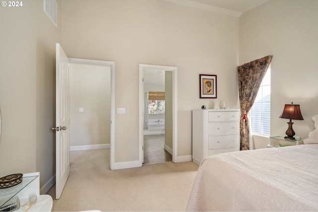 bedroom with light colored carpet and a towering ceiling