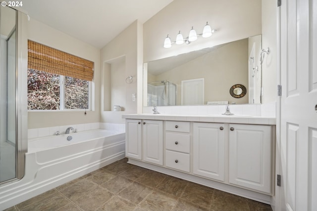 bathroom featuring vanity, independent shower and bath, and vaulted ceiling