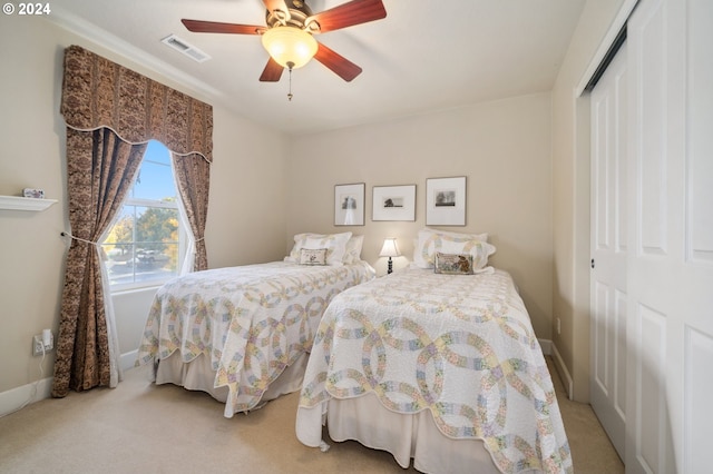 bedroom featuring a closet, ceiling fan, and light carpet