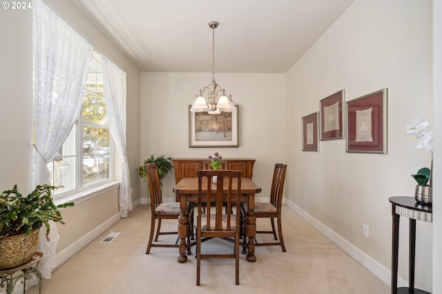 dining space featuring an inviting chandelier and light colored carpet