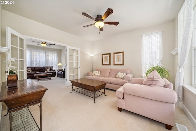 carpeted living room featuring french doors and ceiling fan