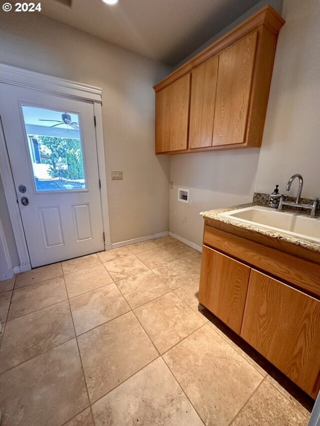 laundry room featuring light tile patterned flooring, cabinets, sink, and hookup for a washing machine