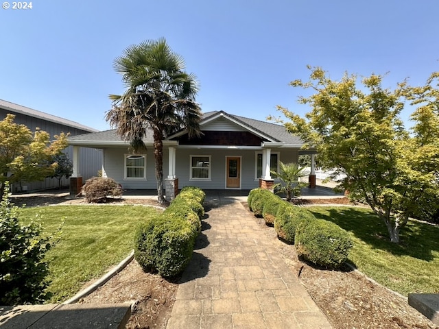 view of front of house with central AC, a front yard, and covered porch