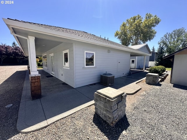 rear view of house featuring central AC unit and a patio area