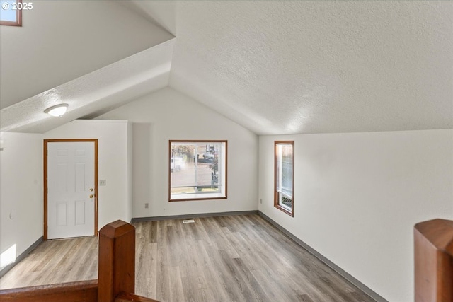 2427 SW 218th Dr, Beaverton, OR 97003 - bonus room featuring a textured ceiling, wood finished floors, lofted ceiling, and baseboards